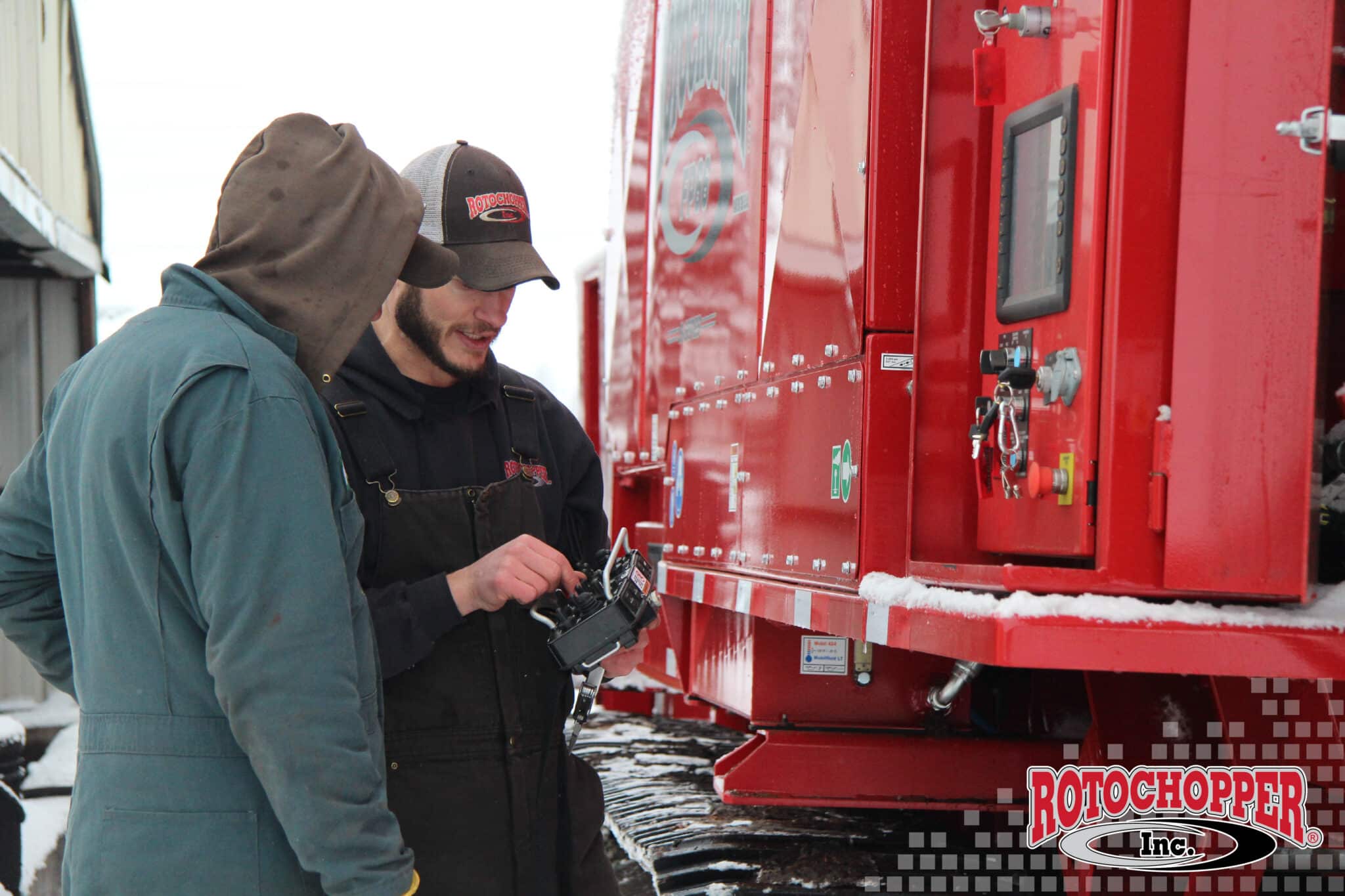 A Rotochopper service technician discusses something with a customer. The Rotochopper logo is in the right-hand corner.